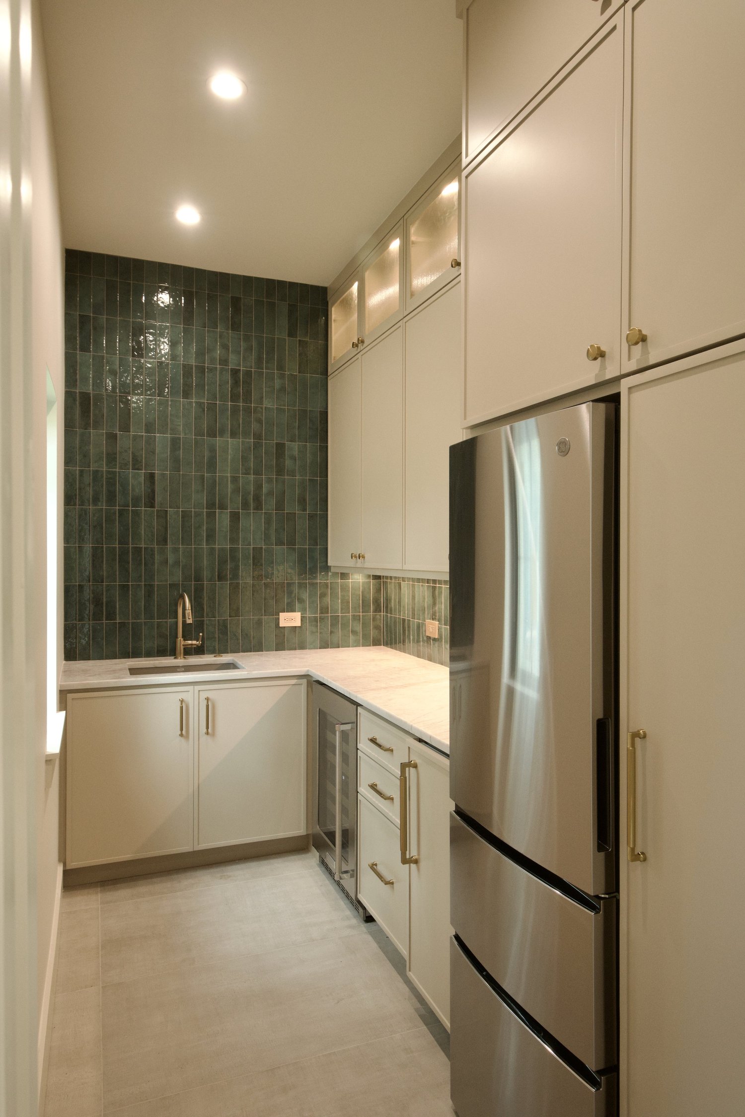 Butler's pantry with wine cooler, ice maker, and prep sink in coordinating oak and quartz