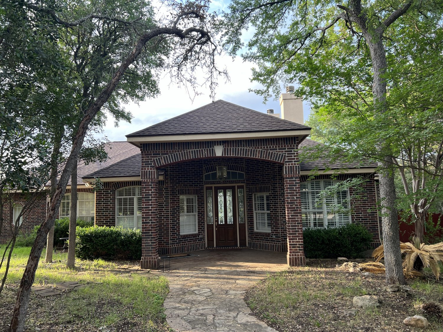 Before: the original red-brick front entry with arched windows