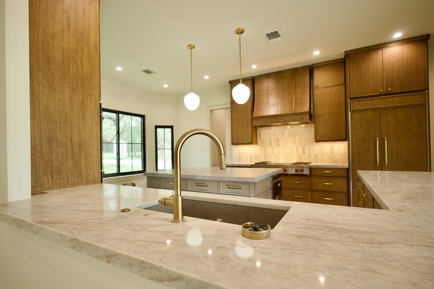 Kitchen island in Perla Mirage quartz with white oak cabinetry
