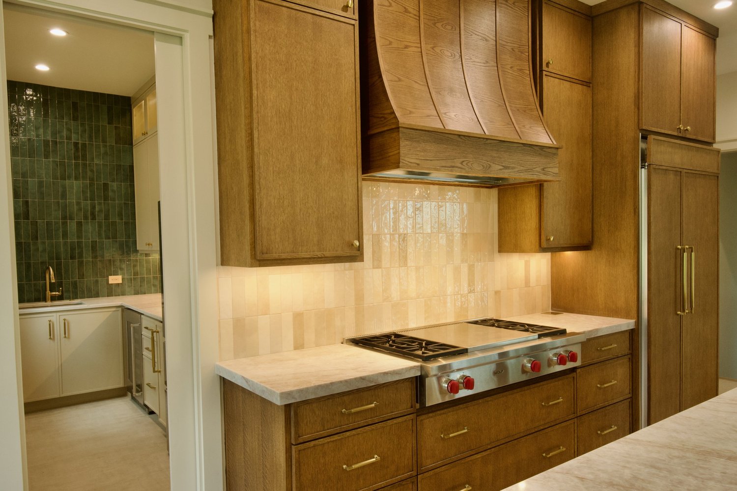 San Marcos project: white oak kitchen with Wolf range and custom vent hood