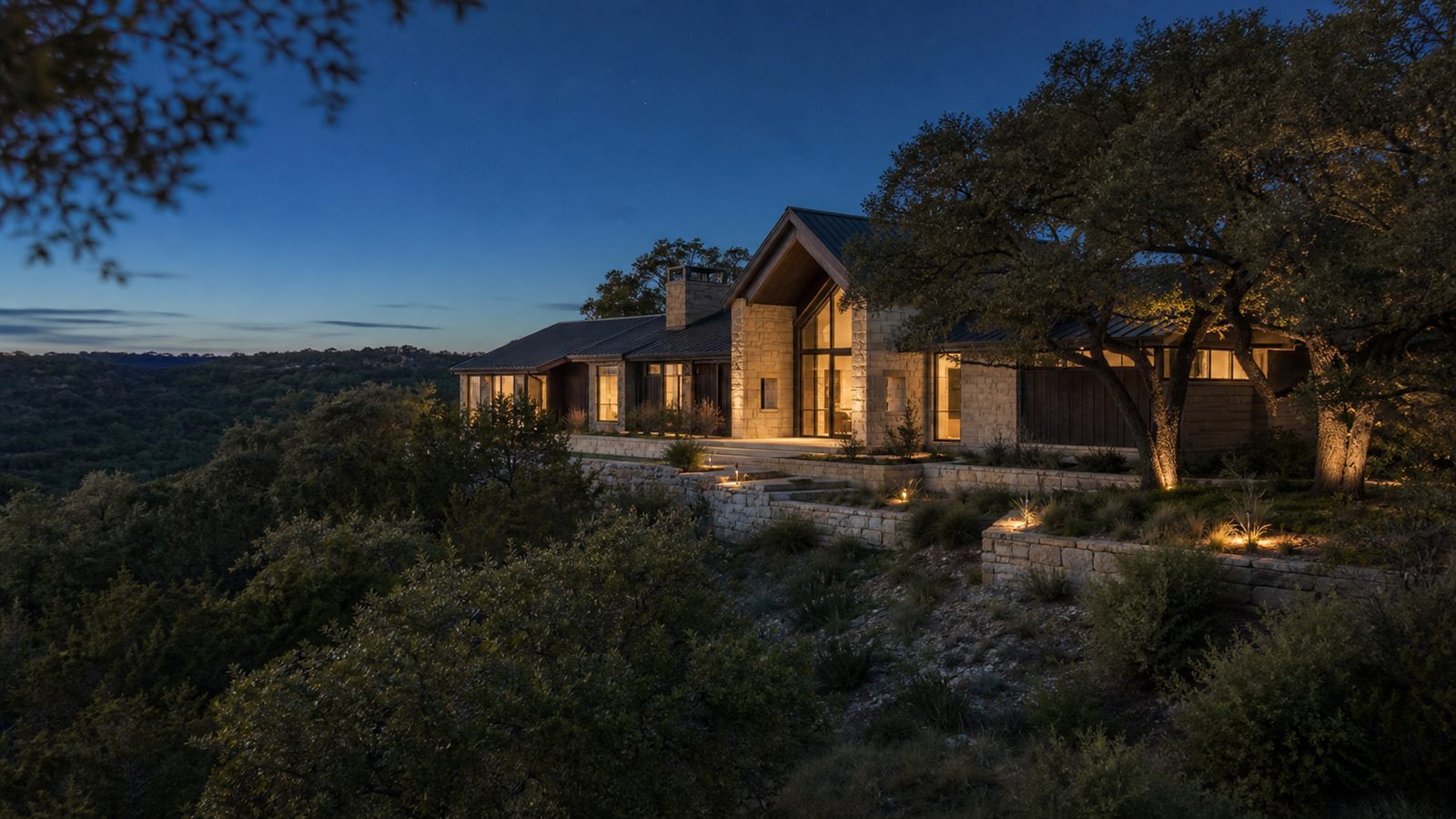 Limestone and wood custom home among Hill Country oaks near Driftwood at golden hour